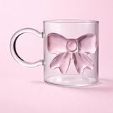 Meturas Pembe Fiyonklu Kulplu Cam Bardak, 350 ml Hacimli Borosilikat Cam Yapısı, Ergonomik Kulbu ve Dekoratif Fiyonk Tasarımıyla Çay, Kahve ve Sıcak Içecek Sunumlarınızda Zarafet Katar. - Şeffaf