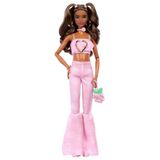 Pembe kot kısa üst ve uyumlu gül desenli ispanyol paça pantolon giyen, gül şeklinde el çantası ve takı gibi aksesuarları olan dalgalı kahverengi saçlı Barbie Deluxe Style bebek (12), JJN72